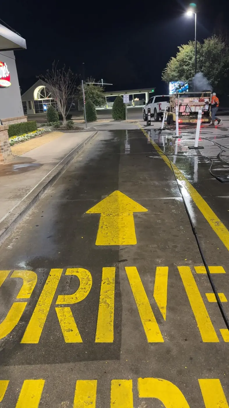 Raising Cane's drive-thru lane half washed at night, clean side next to dirty side